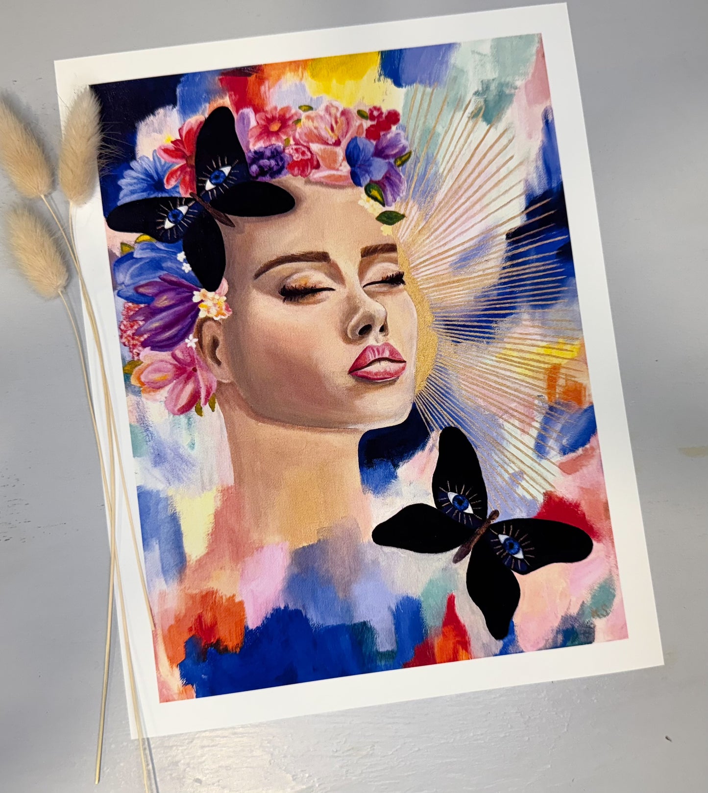 Colorful art print of a woman's face with butterflies and flowers on a gray background
