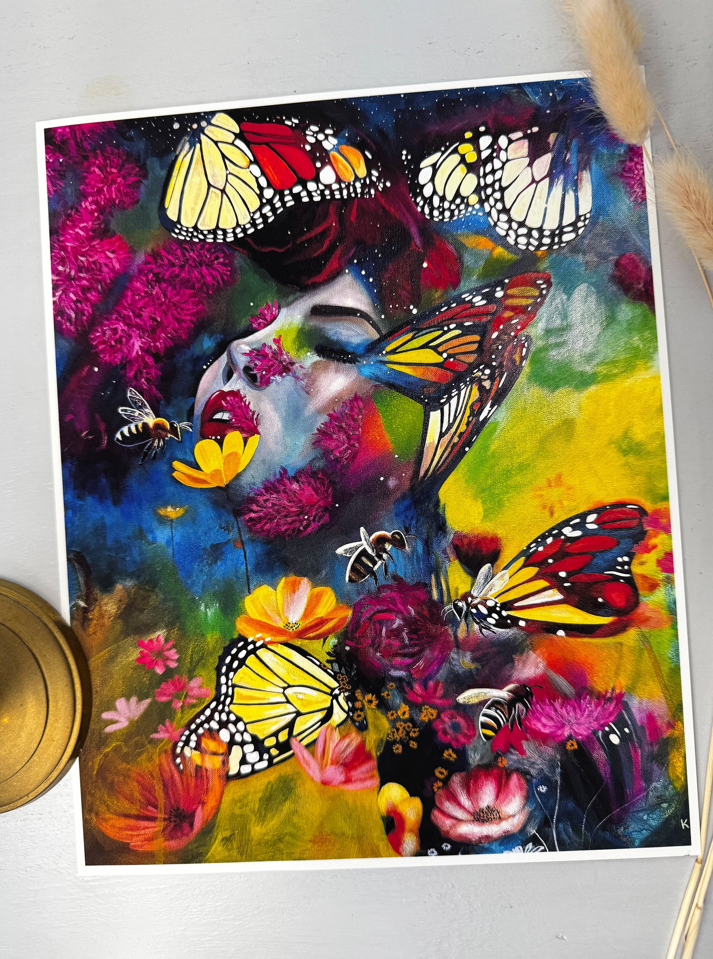 Colourful art print of a woman's face with butterflies, bees and flowers on a white background