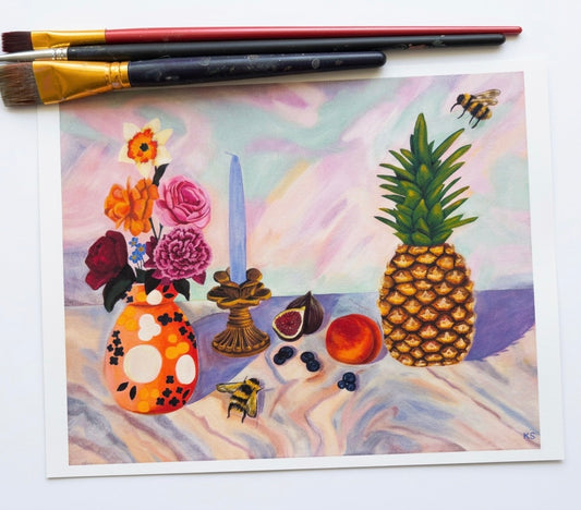 A print of fruit including a pineapple, a bee, a candle and a vase full of flowers