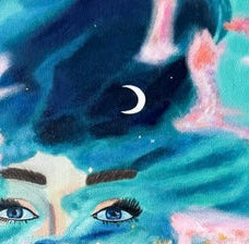 A close up of a painted galaxy and the top of a woman’s head with a moon