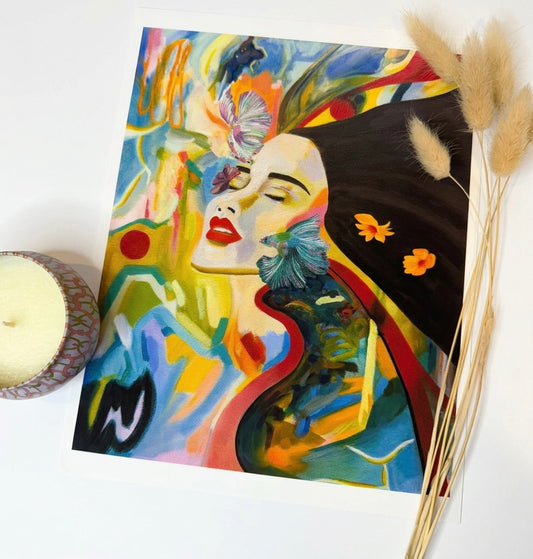 A print of a woman with two Siamese fighting fish surrounded by abstract swatches of paint. 