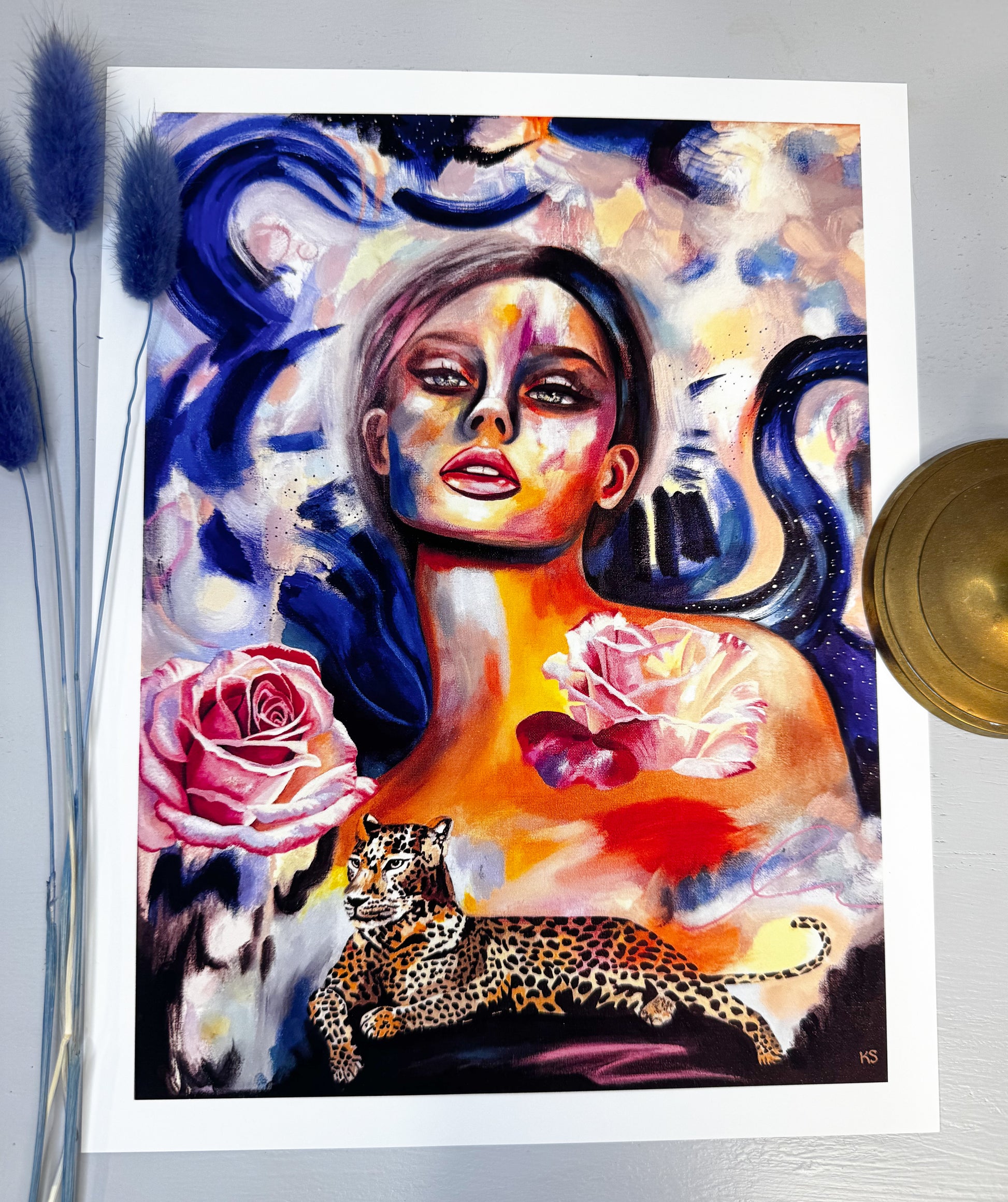 Colorful artwork of a woman with abstract elements, flowers, and a leopard on a white background.