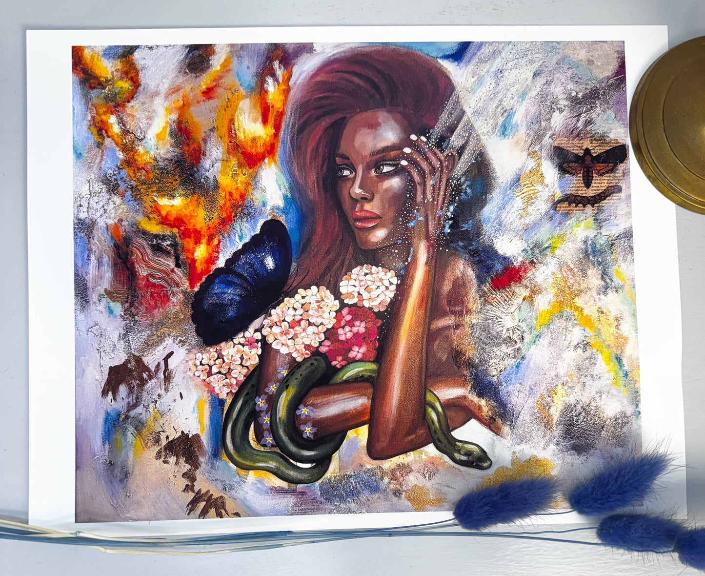 Artistic depiction of a woman with flowers and a snake, surrounded by abstract elements.