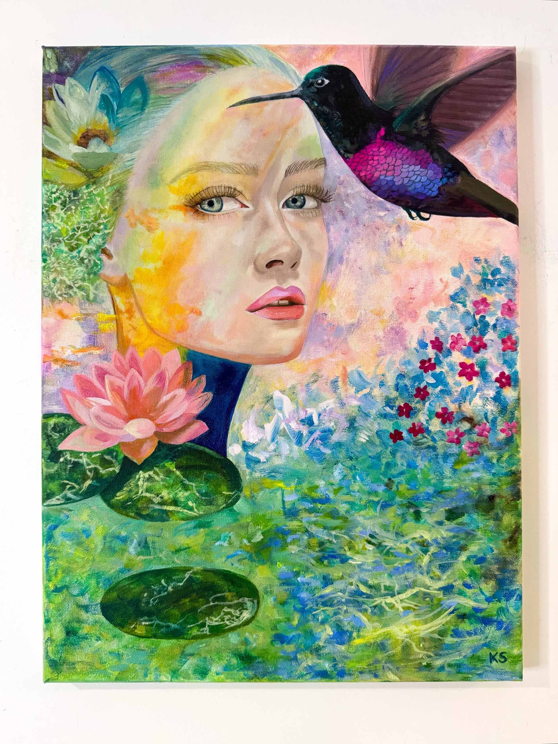 Artistic depiction of a woman's face with a hummingbird and floral elements