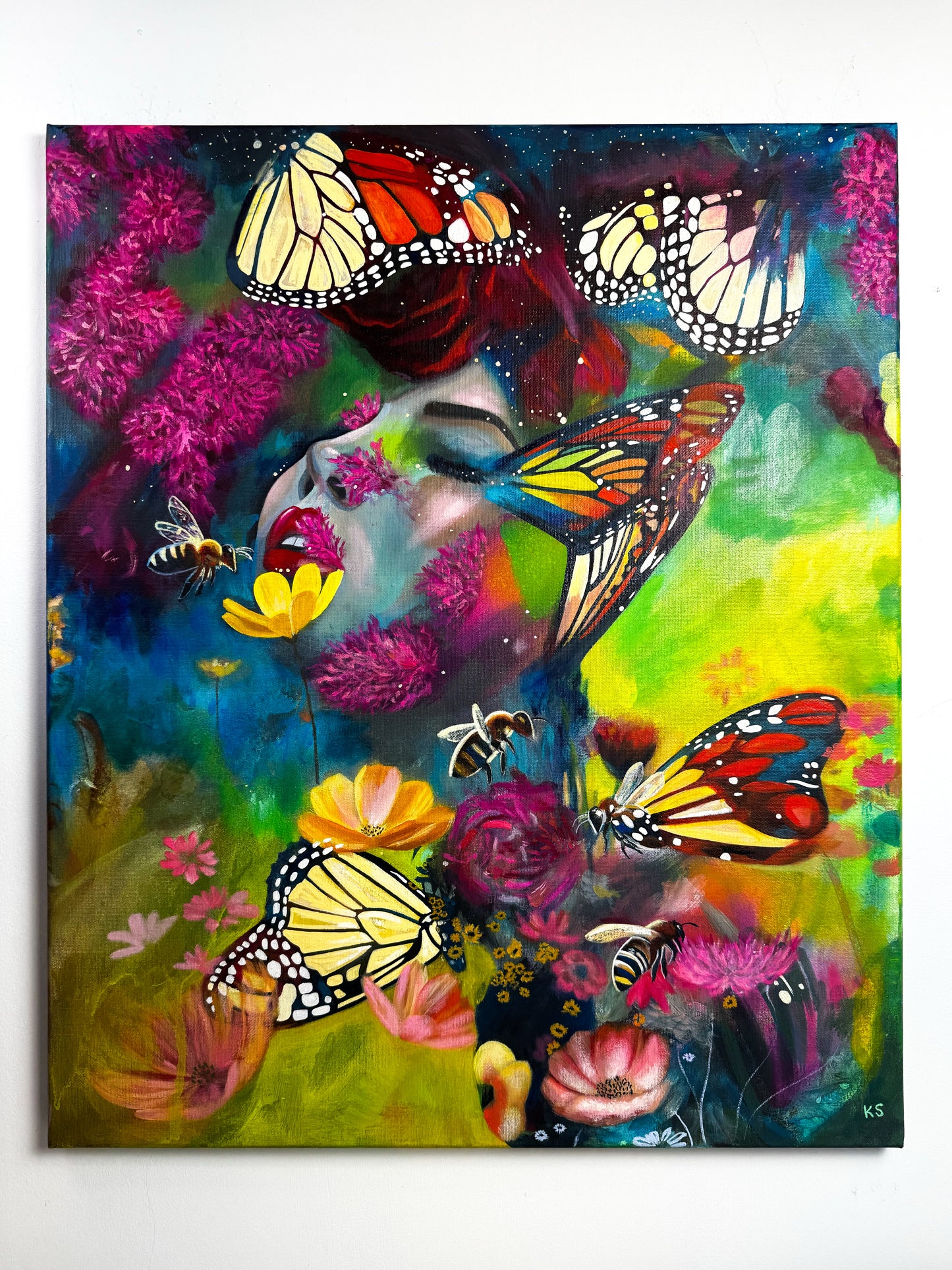 Colorful artwork of a woman's face surrounded by butterflies, bees and flowers on a white background