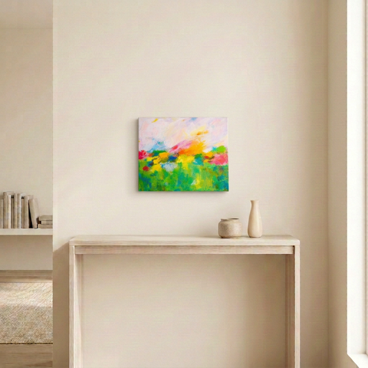 Garden Party, a colourful landscape abstract painting, displayed unframed above a pale wood console in a neutral room.